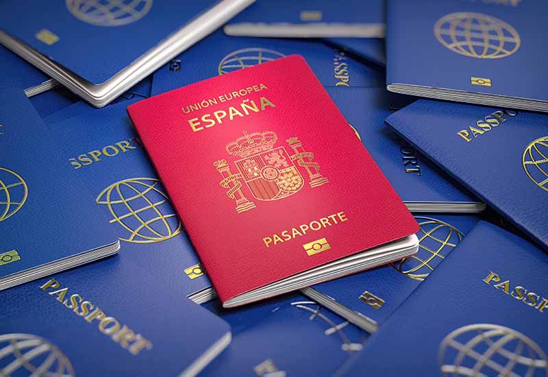 varios pasaportes azules donde sobresale uno rojo de España